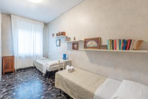 pokój z 3 łóżkami i oknem z książkami w obiekcie Montebello, Bologna by Short Holidays w Bolonii