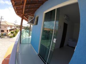 einen seitlichen Blick auf ein blaues Gebäude mit einem Balkon in der Unterkunft Xodó do Peró Hostel in Cabo Frio