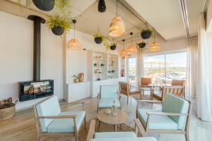 a living room with chairs and a tv and a table at Sleep & Nature Hotel in Lavre