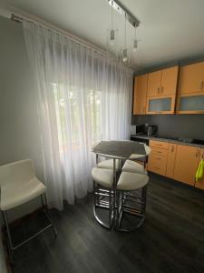 uma cozinha com mesa e cadeiras e uma janela em AVapartment em Mākoņkalns