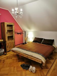 a bedroom with a large bed and a red wall at Apartmaji ARKO in Ribnica