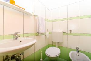 Baño blanco con lavabo y aseo en Apartment 3M, en Trogir