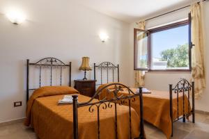 een slaapkamer met 2 bedden en een raam bij Appartamento Limone in Carovigno