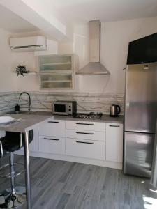 uma cozinha com armários brancos e um frigorífico de aço inoxidável em Apartment Smile em Opatija
