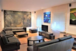 una sala de estar con un sofá y una mesa en Casa con terrazas, en Zaragoza