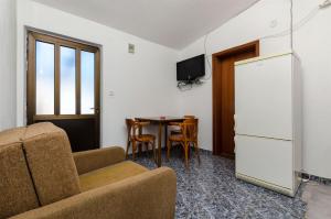 a living room with a couch a table and a refrigerator at House Sliskovic in Rogač