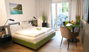 1 dormitorio con 1 cama y 1 mesa con silla en City Appartements Villach, en Villach
