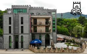 um edifício com um guarda-chuva azul em frente em Gelati Tower em Gelat'i