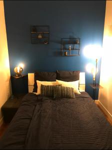 a bedroom with a large bed with a blue wall at Olympic Games 20 min from Paris and CDG Aeroport Luxurious House with garden and parking in Eaubonne