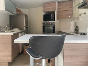 a kitchen with a black chair at a counter at Olympic Games 20 min from Paris and CDG Aeroport Luxurious House with garden and parking in Eaubonne