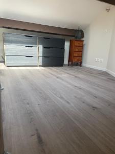 an empty room with a dresser and a wooden floor at Olympic Games 20 min from Paris and CDG Aeroport Luxurious House with garden and parking in Eaubonne
