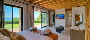 a bedroom with a large bed and large windows at Aquavisionaire Beach Front Villa in Líndos