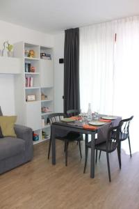 a dining table and chairs in a living room at Borgo Apartments Borgo 56 in Borgomanero