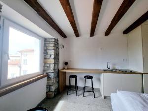 a kitchen with two stools in a room with a window at Akvatour Apartments Piran in Piran