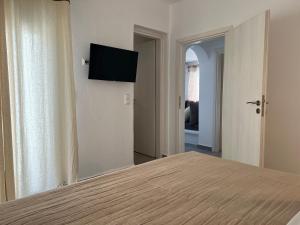 a bedroom with a bed with a flat screen tv on the wall at Villa stou Chiou in Agia Anna Naxos