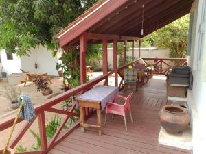 eine Holzterrasse mit einem Tisch und Stühlen darauf in der Unterkunft Ezime Guesthouse And Pizzeria in Ada