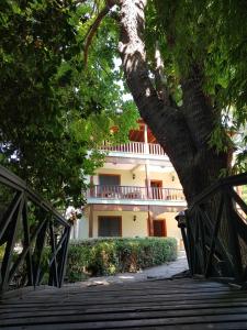 a wooden bridge leading to a building with a tree at Pinea Hotel in Kemer