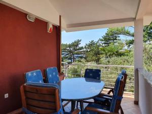 un tavolo con sedie in una camera con balcone di Villa Red Rose a Njivice