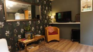 uma sala de estar com um espelho e uma cadeira em B&B aan het bos em Ter Apel