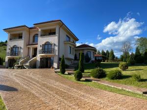 una gran casa blanca con entrada adoquinada en Vila Daria 3, en Rucăr