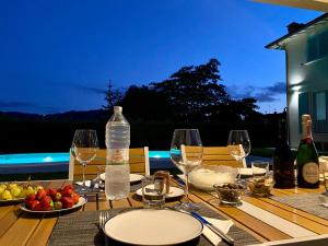 un tavolo con bicchieri da vino e una bottiglia d'acqua di Villa Lena a Camaiore