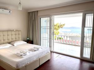 a bedroom with a bed and a large sliding glass door at BODRUM BURCU VILLA , Magnificent Sea View, Cozy, Free Otopark, Free Wifi in Bodrum City