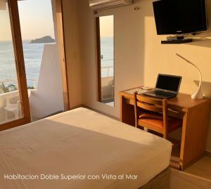 a bedroom with a desk with a laptop and a window at Hotel Be La Sierra in Santa Marta