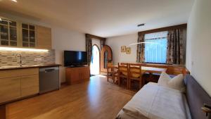 kuchnia i salon z kanapą i stołem w obiekcie Residence Granvara w mieście Ortisei