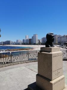 Apartamento Costa Riazor Coruña في لا كورونيا: تمثال تمثال لشخص على الشاطئ