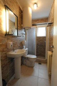 uma casa de banho com um lavatório, um WC e um espelho. em Hostel Fair and Square em Belgrado