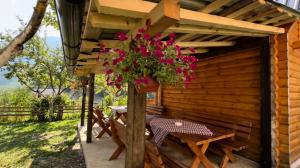 a patio with a table and flowers on a cabin at Guest House Kollata in Vusanje