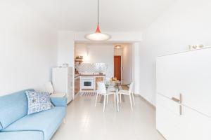 Una sala de estar con un sofá azul y una mesa. en Residence Erice Beach Seaview Apartment with Swimming Pool, en Trapani