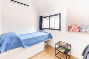 Un pequeño dormitorio con una cama azul y una ventana en Residence Erice Beach Seaview Apartment with Swimming Pool, en Trapani