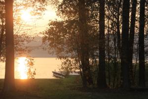 um pôr-do-sol sobre um corpo de água com uma doca em Gospodarstwo Gościnne Racibór em Świętajno