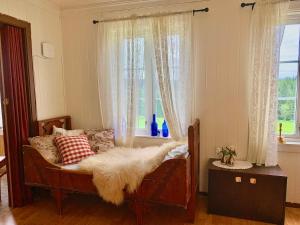 LandsemにあるLandlig leilighetのソファ、枕、窓が備わる客室です。
