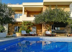 a villa with a swimming pool in front of a house at House Arija in Makarska