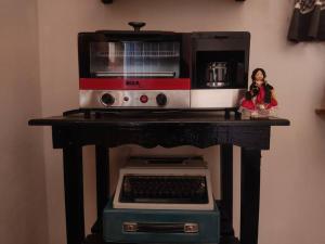 a doll sitting on a table with a microwave at Casa de huéspedes con lo que necesitas para ti in San Pablo Villa de Mitla