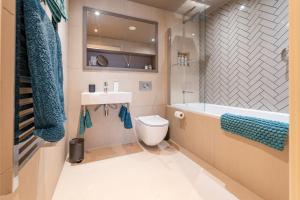 a bathroom with a tub and a toilet and a sink at Entire 2 Bed - Free Parking - No. 35 - The Cosy Collection Ltd in York