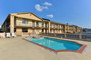 une piscine en face d'un bâtiment dans l'établissement Americas Best Value Inn Arkadelphia, à Arkadelphia