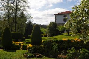 un jardin devant une maison avec des arbres et des buissons dans l'établissement Vivienda Rural - Apartamentos La Cueva - Hornedo, à Entrambasaguas 16 autres photos