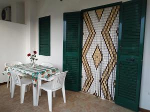 a dining room with a table and chairs and a wall at Villa Scialara in Vieste