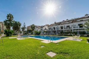 a swimming pool in the middle of a yard with buildings at Sur Suites Castillo in Fuengirola