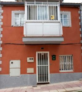 a red building with a door and a balcony at APARTAMENTO MADRID Norte in San Sebastián de los Reyes