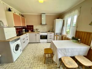 a kitchen with a table and chairs and a kitchen with white appliances at Landlig leilighet in Landsem +12 photos