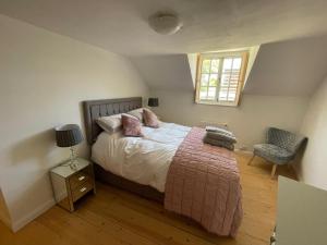 a bedroom with a bed and a chair and a window at Central townhouse in Woodstock