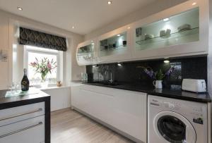 a kitchen with a washer and dryer and a window at The Old School House - Cosy 3 bedroom Cottage in Wick
