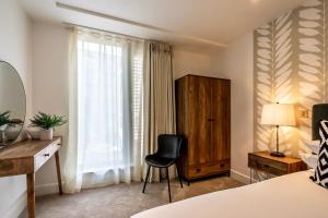 een slaapkamer met een stoel, een bureau en een raam bij Apartment 212 @ Ryedale House in York
