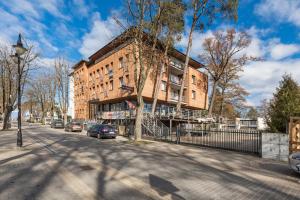 ミエルノにあるApartament 300 Planeta Mielno z garażemの車が通りに駐車した建物