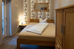 een slaapkamer met een bed, een dressoir en een spiegel bij FW Rheinblick in Sankt Goar
