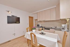 a kitchen with a white table and chairs in a room at Apartment Mate in Omiš +15 photos